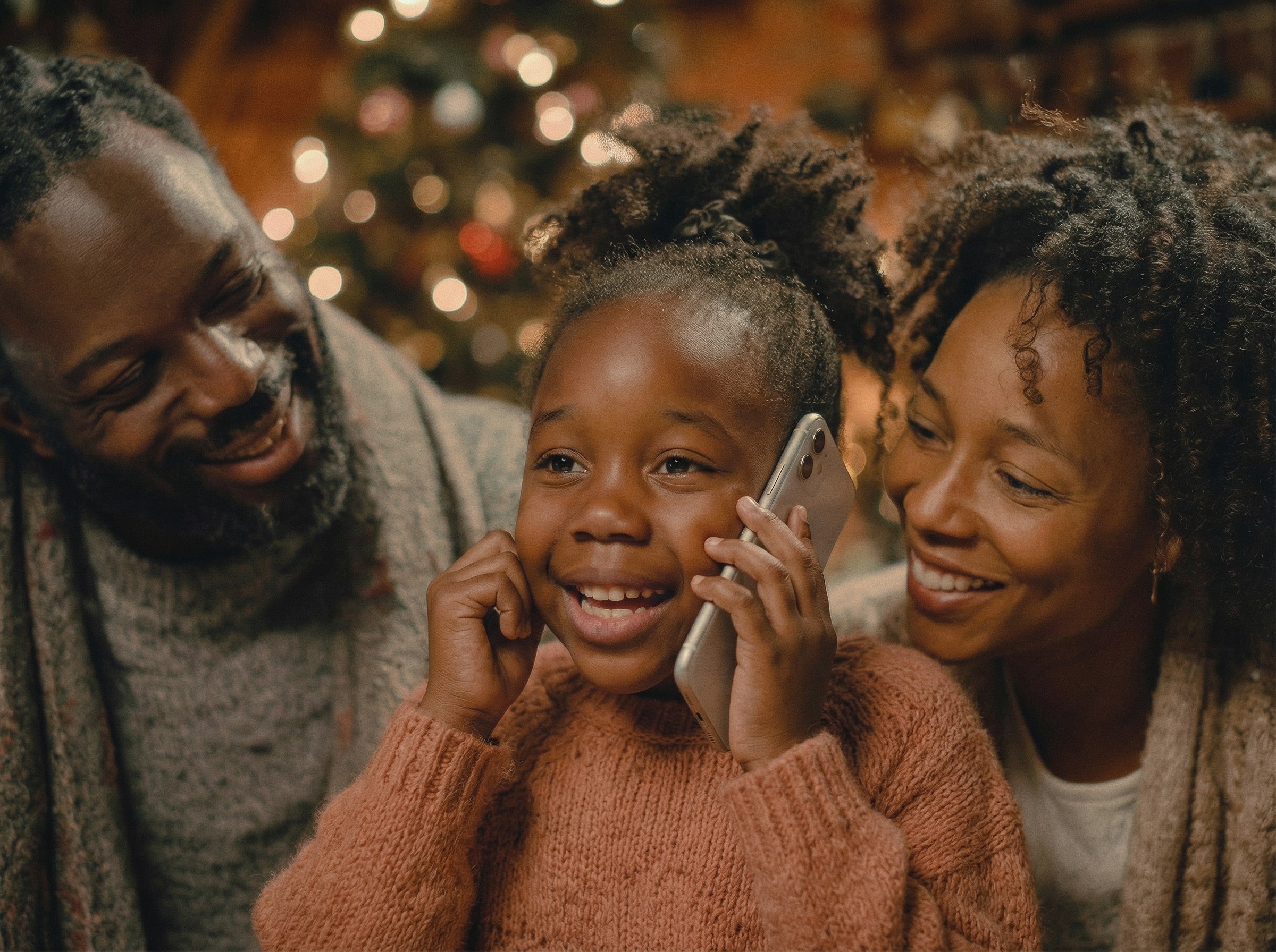 A joyful child talking with Santa Claus, with their family and a decorated Christmas tree in the background